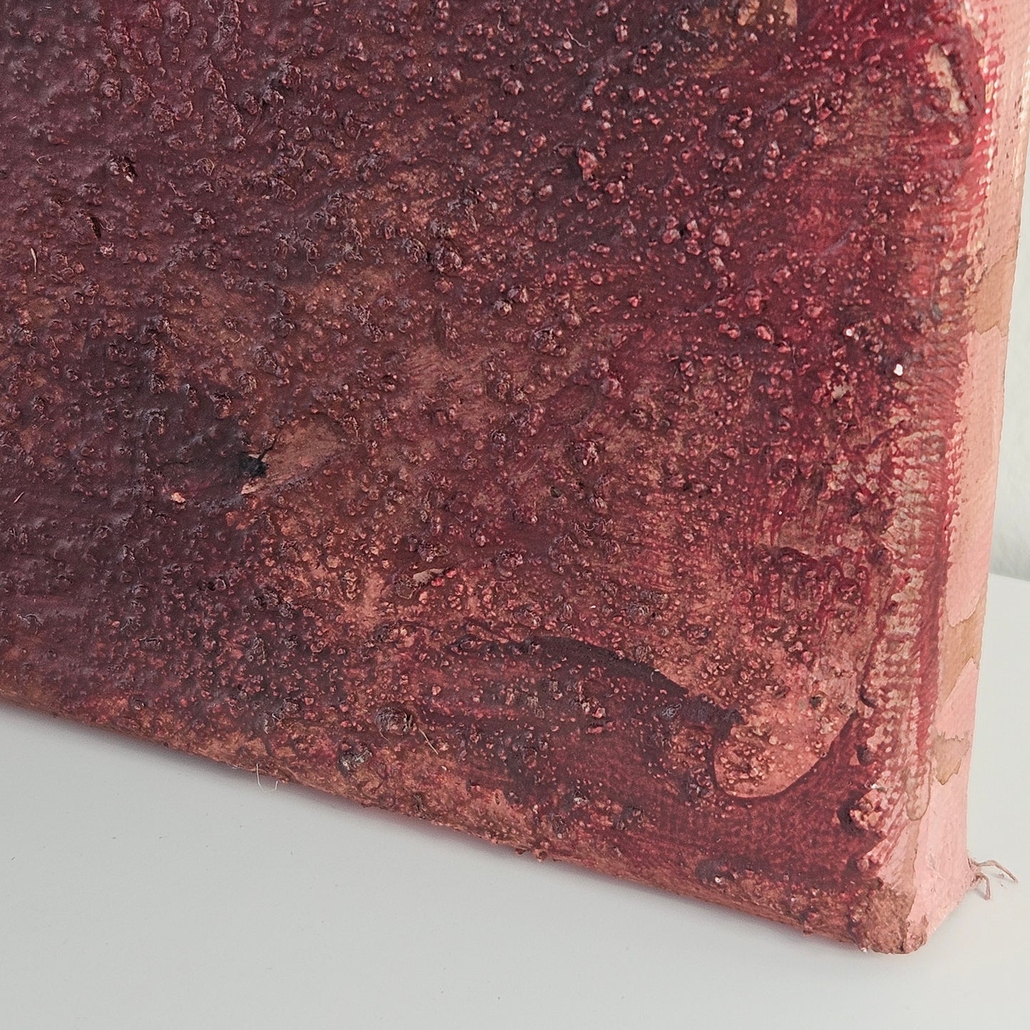 Detail einer unteren Ecke der Leinwand mit abstrakter rostroter körniger Textur mit Gebrauch von Kaffeesatz. Eine rustikale, erdige und warme Farbgebung. Künstlerin Lola Kuoni hat ihr Atelier in Nottuln, Münsterland.
