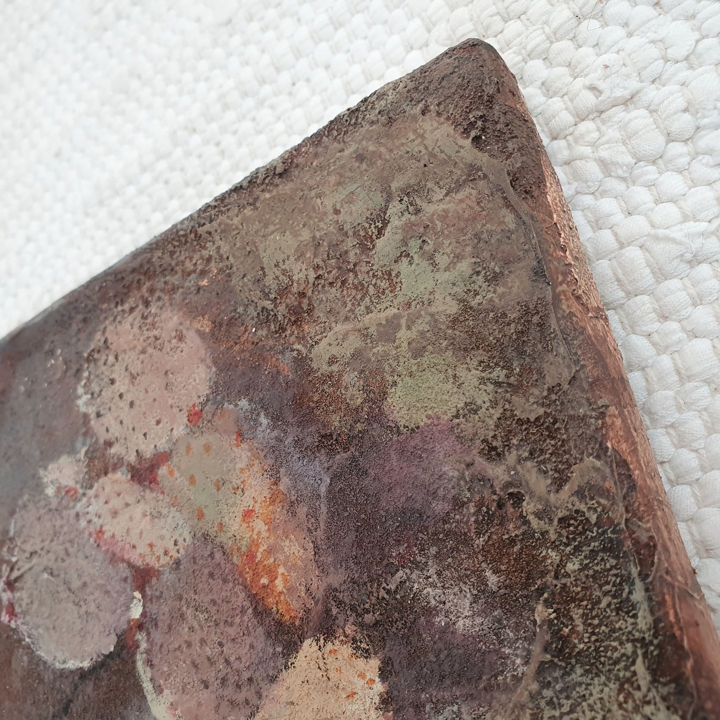 Ein Detail der rauen, matten Oberfläche mit erdiger Farbgebung. Patinagrün legt sich über das rustikale und erdige Braun. Eine Kaktuspflanze als figuratives Detail erzeugt Spannung.