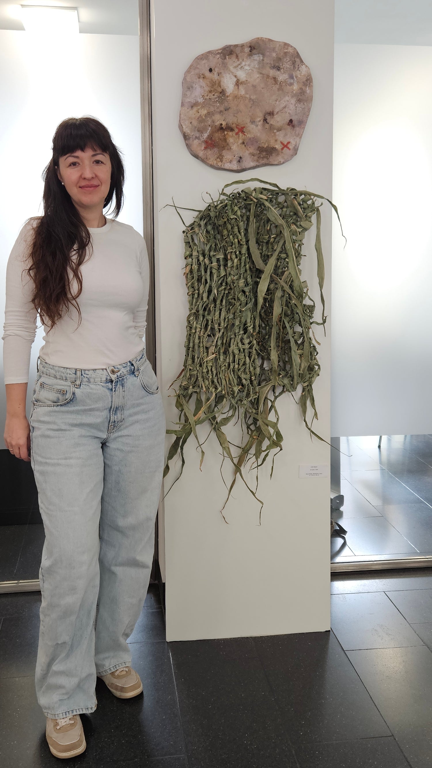 Lola Kuoni neben ihrem Kunstwerk "als wäre" bei der Ausstellung 2026 Diözesanbibliothek Münster Schanze
